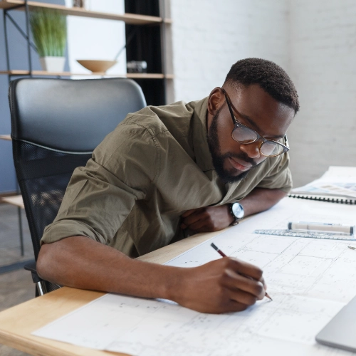 Infrastructure professional reviewing technical project plans at a desk